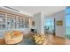 Open living room featuring a modern fireplace, custom bookshelves, and an adjacent office with waterfront views at 280 Golden Gate Pt # 400, Sarasota, FL 34236