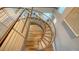 Unique curved staircase featuring wood steps and a modern railing system at 280 Golden Gate Pt # 400, Sarasota, FL 34236