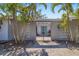 View of the property entrance featuring a gate and palm trees against a blue sky at 3086 Pinecrest St, Sarasota, FL 34239