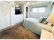 Comfortable bedroom with built-in storage, a TV, neutral walls, and a matching bedspread at 3335 Spanish Oak Ter, Sarasota, FL 34237