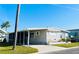 Inviting single-story home with carport and palm trees set against a clear blue sky at 3335 Spanish Oak Ter, Sarasota, FL 34237