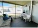 Enclosed porch area with a mix of seating, neutral colors, and views of the neighborhood at 3335 Spanish Oak Ter, Sarasota, FL 34237