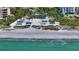 Community beach with blue roofed structures and beach access from above at 3540 Mistletoe Ln, Longboat Key, FL 34228