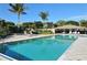 Community pool area with a covered seating area, lounge chairs, and lush landscaping at 3540 Mistletoe Ln, Longboat Key, FL 34228