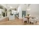 Bright dining area adjacent to kitchen featuring modern lighting, wooden floors, and an airy open space at 3540 Mistletoe Ln, Longboat Key, FL 34228