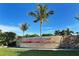 Entrance to Corbey's Landing featuring lush greenery and professional landscaping under a clear blue sky at 3540 Mistletoe Ln, Longboat Key, FL 34228