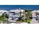 Coastal home featuring a white roof, three-car garage, and lush landscaping with direct access to the beach at 3540 Mistletoe Ln, Longboat Key, FL 34228