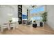 Open-concept living room featuring floor-to-ceiling windows, fireplace, modern decor and light wood floors at 3540 Mistletoe Ln, Longboat Key, FL 34228