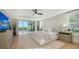 Main bedroom features light-colored decor, a ceiling fan, and sliding glass doors leading to a balcony at 3540 Mistletoe Ln, Longboat Key, FL 34228