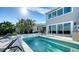 Inviting backyard pool area with lounge seating and palm trees offering shade at 3540 Mistletoe Ln, Longboat Key, FL 34228