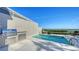 Inviting pool area with an outdoor kitchen, grill, and lounge chairs overlooking the water at 3540 Mistletoe Ln, Longboat Key, FL 34228