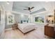 Charming bedroom featuring tray ceilings, wood floors, serene paint color, and multiple windows providing natural light at 3595 Shamrock Dr, Venice, FL 34293