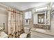 Bathroom featuring a shower with palm tree curtain, granite countertop, and vanity with a mosaic backsplash at 3698 Lake Bayshore Dr # K-410, Bradenton, FL 34205