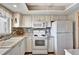 Well-maintained white kitchen with stainless steel appliances, granite countertops, and modern backsplash at 3698 Lake Bayshore Dr # K-410, Bradenton, FL 34205