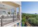 Balcony with wrought iron railing overlooks waterfall and landscaping with ocean view at 3935 N Shell Rd, Sarasota, FL 34242