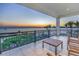 Expansive balcony with seating overlooking the ocean and a stunning sunset, showcasing the beautiful coastal scenery at 3935 N Shell Rd, Sarasota, FL 34242