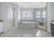Bright bathroom boasts a soaking tub with ocean view and glass enclosed shower at 3935 N Shell Rd, Sarasota, FL 34242