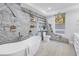 Bright bathroom featuring a modern tub, distinctive stone wall design, and a serene atmosphere at 3935 N Shell Rd, Sarasota, FL 34242