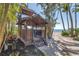 Charming tiki hut nestled on a sandy beach with ocean views and lush greenery at 3935 N Shell Rd, Sarasota, FL 34242