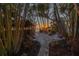 Path through lush tropical landscaping leading to the beach with tiki hut and stunning sunset at 3935 N Shell Rd, Sarasota, FL 34242