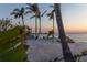 Relaxing beach seating with amazing sunset view and palm trees offering shade on a bright sunny day at 3935 N Shell Rd, Sarasota, FL 34242
