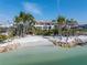 Expansive beachfront estate with pristine sands, turquoise waters, and lush palm trees under a clear, blue sky at 3935 N Shell Rd, Sarasota, FL 34242