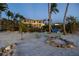 Beautiful beachfront house with a large balcony, sandy beach, and outdoor seating around a fire pit at 3935 N Shell Rd, Sarasota, FL 34242