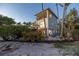 An exterior shows the home with balconies, a landscaped hillside, and a sandy beach with water access at 3935 N Shell Rd, Sarasota, FL 34242