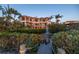 An exterior shows the home with balconies overlooking lush landscaping, a pond, and a wooden dock with fountain at 3935 N Shell Rd, Sarasota, FL 34242