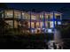 Multi-story home with balconies, large windows, and lush landscaping viewed at dusk at 3935 N Shell Rd, Sarasota, FL 34242
