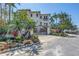 Mediterranean-style home exterior with lush landscaping, private gate, and brick driveway at 3935 N Shell Rd, Sarasota, FL 34242