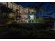 Luxurious multi-story home at night with balconies, lush greenery, and a tranquil water feature at 3935 N Shell Rd, Sarasota, FL 34242