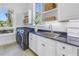 Well-lit laundry room featuring bright white cabinetry, granite countertops, and a window view at 3935 N Shell Rd, Sarasota, FL 34242