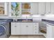 Well-organized laundry room features custom cabinetry and granite countertops, with modern appliances at 3935 N Shell Rd, Sarasota, FL 34242