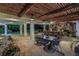 Covered outdoor dining and bar area featuring wood ceiling, stone wall, and tropical landscaping at 3935 N Shell Rd, Sarasota, FL 34242
