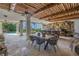 This covered patio features a stone accent wall, wooden ceiling, dining and bar seating, and views of the pool and landscaping at 3935 N Shell Rd, Sarasota, FL 34242