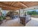 This covered patio has wooden ceilings, a stone kitchen, a rock waterfall wall, and outdoor seating at 3935 N Shell Rd, Sarasota, FL 34242