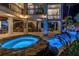 Stunning outdoor pool and hot tub area with rock features and illuminated with ambient lighting for evening relaxation at 3935 N Shell Rd, Sarasota, FL 34242