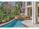 A luxurious outdoor area showcases a sparkling pool, a stone waterfall spa, and an outdoor kitchen with ample counterspace at 3935 N Shell Rd, Sarasota, FL 34242