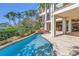 A beautiful outdoor area shows a lagoon-style pool with a stone waterfall, tropical foliage and a lovely, covered lanai at 3935 N Shell Rd, Sarasota, FL 34242