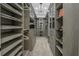 Walk-in closet featuring custom shelving, drawers, and cabinets with a decorative chandelier at 3935 N Shell Rd, Sarasota, FL 34242