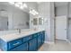 Bright bathroom with blue cabinets, double sinks, large mirrors, and updated fixtures provides plenty of storage at 428 Islebay Dr, Apollo Beach, FL 33572
