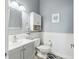 Cozy bathroom with gray vanity, white wainscoting, and decorative accents adds a touch of charm at 428 Islebay Dr, Apollo Beach, FL 33572
