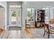 Welcoming entryway with light wood floors, white trim and a view of the front yard through glass paneled front door at 428 Islebay Dr, Apollo Beach, FL 33572