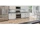 Modern kitchen with stainless steel appliances, white cabinets, granite countertops, and wood-look floors at 428 Islebay Dr, Apollo Beach, FL 33572