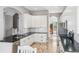 Well-lit kitchen featuring white cabinetry, granite countertops, stainless steel appliances, and wood-look flooring at 428 Islebay Dr, Apollo Beach, FL 33572