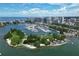 Stunning aerial view of a marina, bay, and city skyline on a sunny day with clear blue skies and fluffy white clouds at 4318 Woodmans Chart # 136, Sarasota, FL 34235