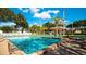 Large community swimming pool with plenty of lounge chairs and lush landscaping with a view of the community buildings at 4330 47Th W Ave # 104, Bradenton, FL 34210