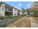 Exterior view featuring screened lanais, lush landscaping, and a well-maintained lawn at 4330 47Th W Ave # 104, Bradenton, FL 34210