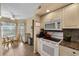 Bright kitchen featuring white appliances, granite countertops, a breakfast nook, and tile flooring at 4330 47Th W Ave # 104, Bradenton, FL 34210